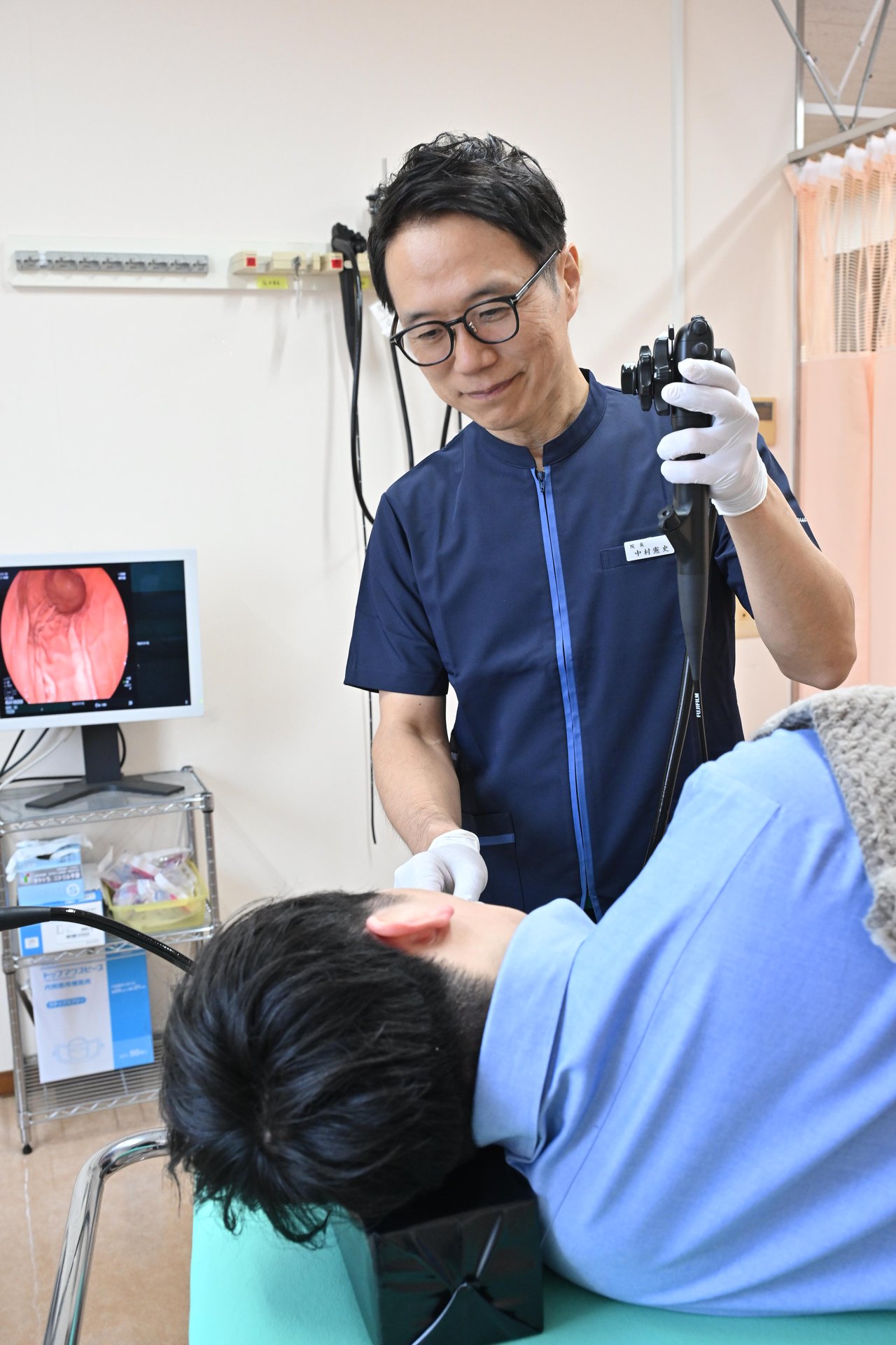 内視鏡室で胃カメラのスコープ機器を保持する院長