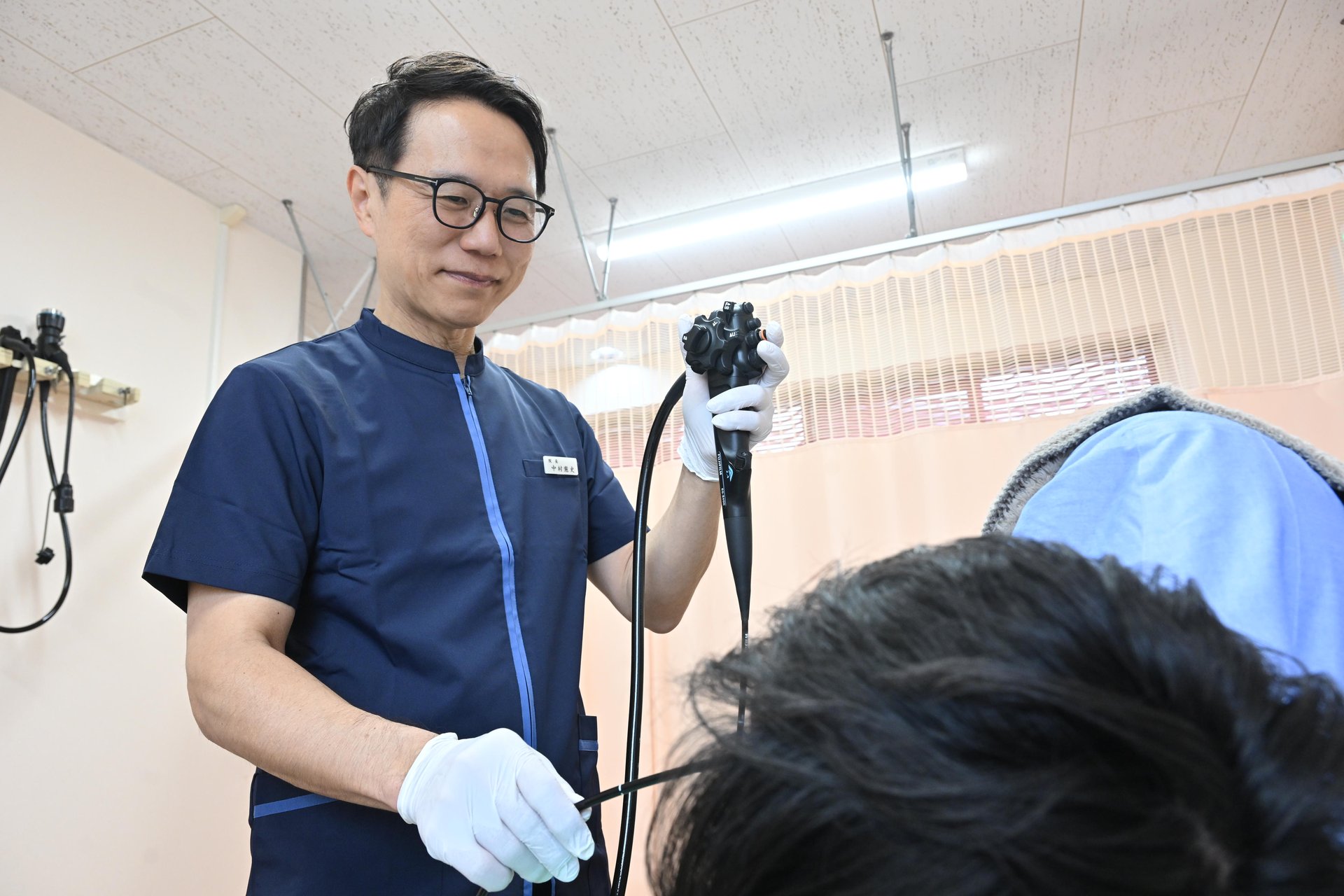 内視鏡を手に検査の説明をする院長